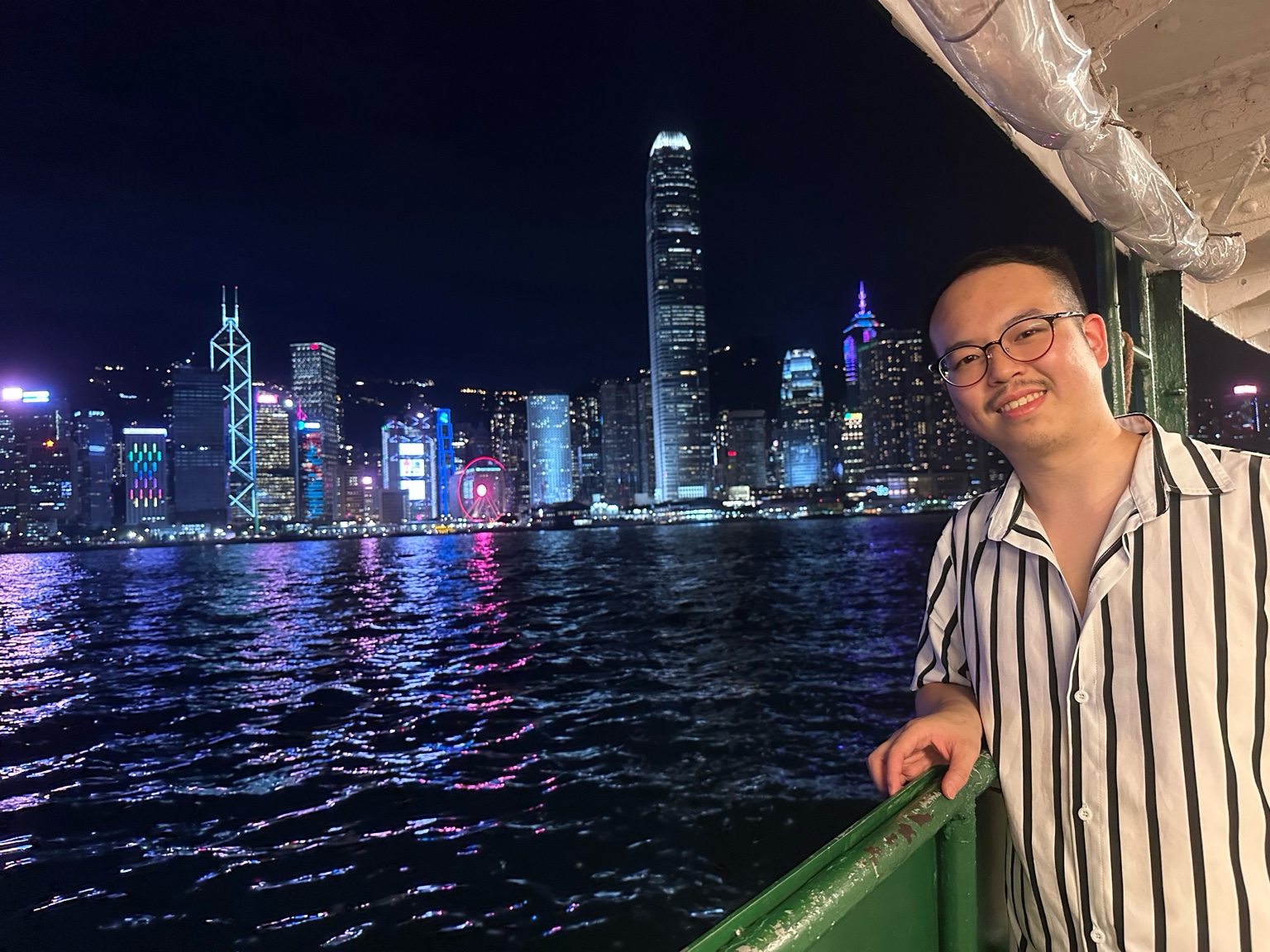 Giacomo sul ferry con skyline di Hong Kong di notte